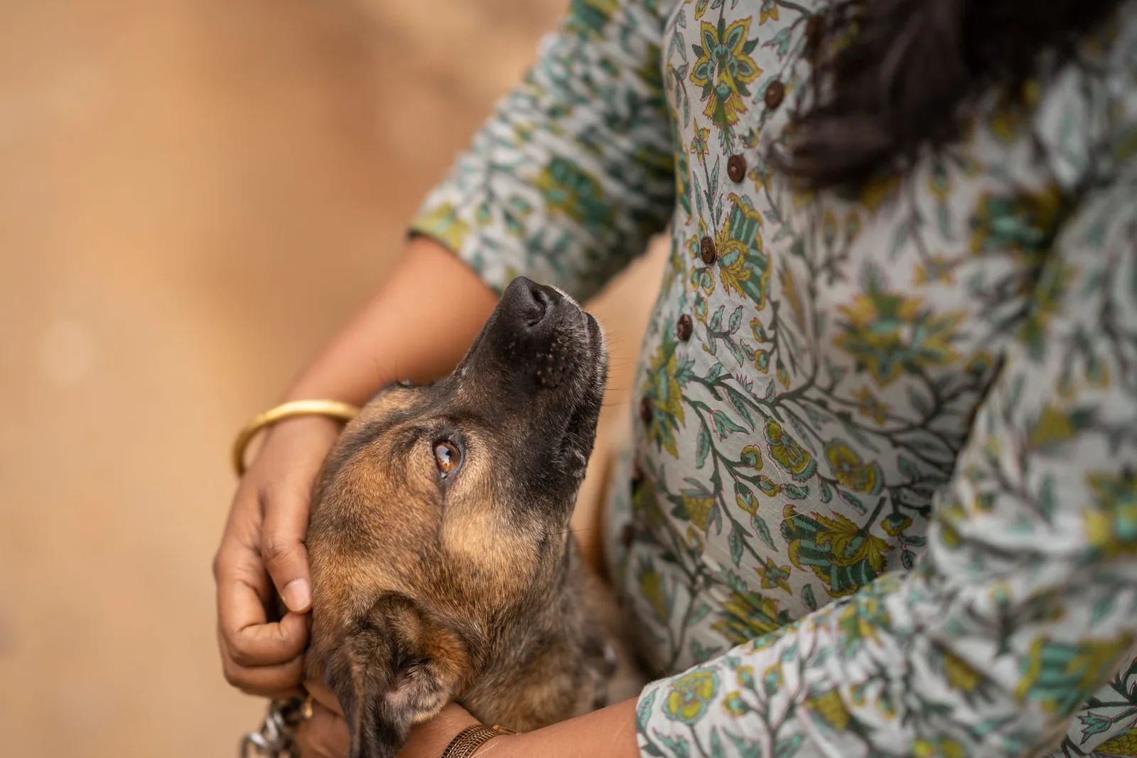 A woman lovingly holding a dog outdoors